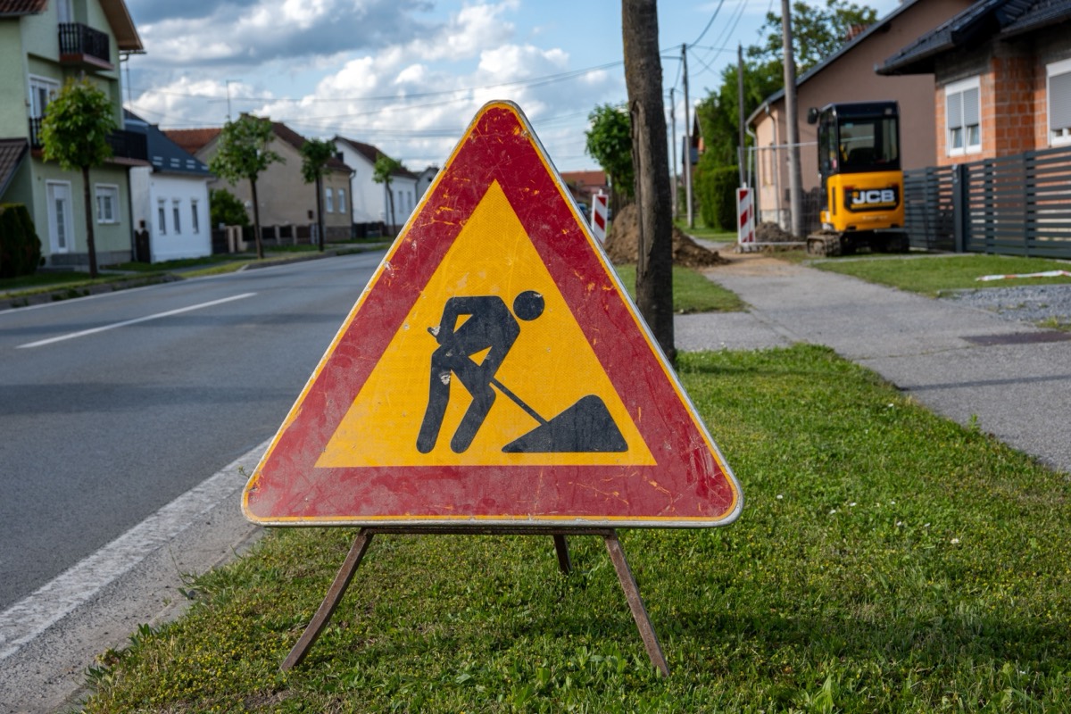 Panneau de travaux et mini-pelle avant détection de réseaux sur un chantier de l'Aube
