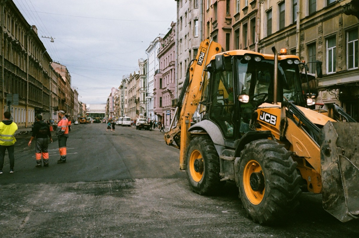 Chantier de voirie avec tractopelle dans une rue dense avant détection de réseaux à Paris