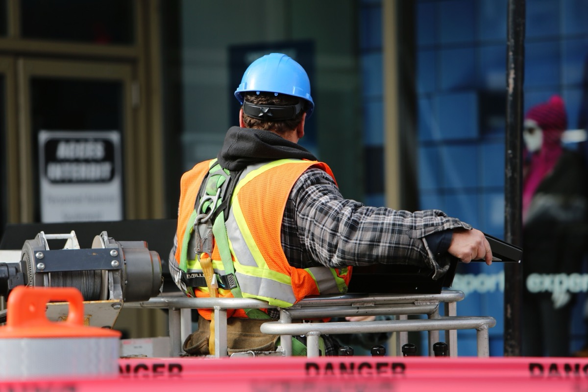 Ouvrier sécurisant la zone autour d'un réseau inconnu avec balisage de danger